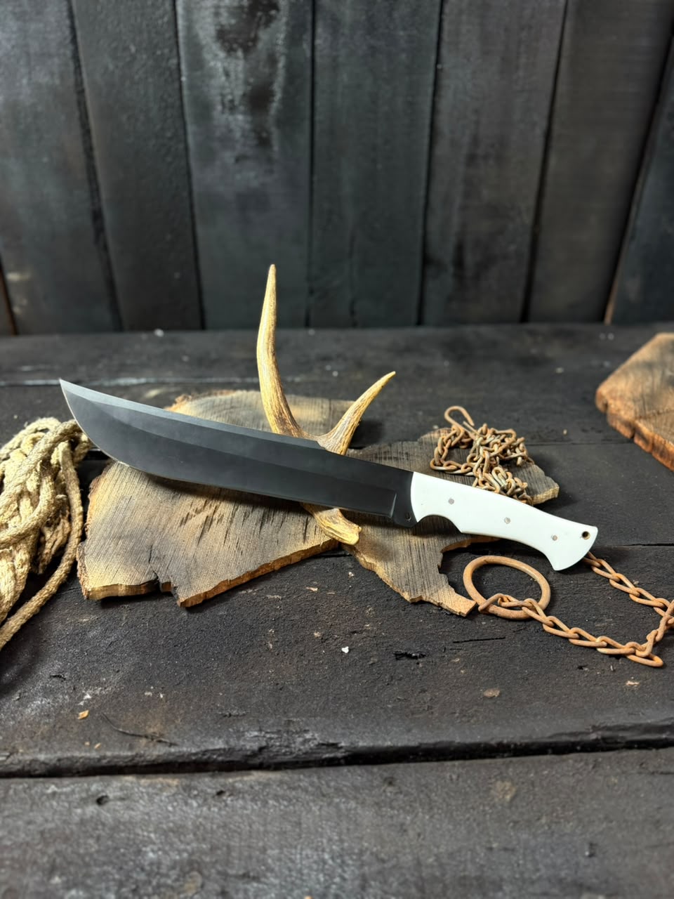 Knife with a chain and antlers on a wooden surface
