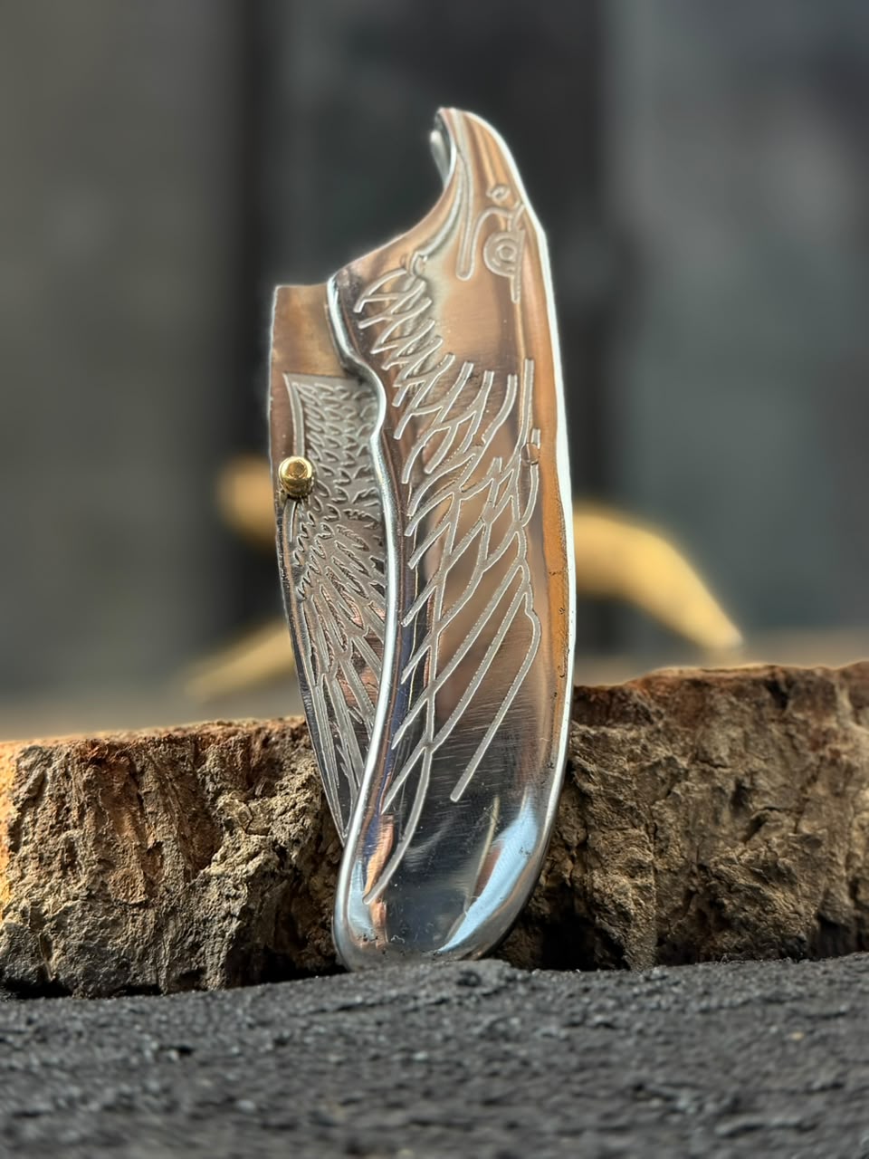 Decorative knife blade with engraved patterns on a wooden surface