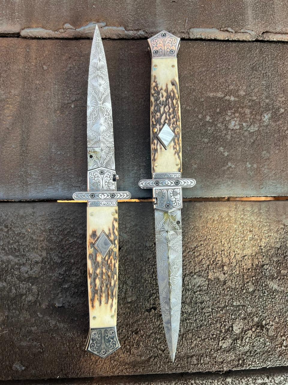 Two ornate knives with decorative handles on a textured surface