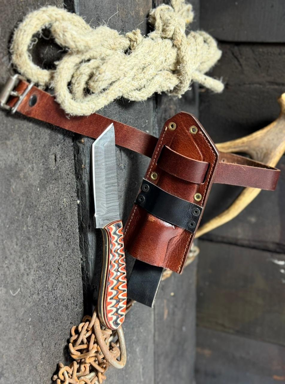 Belt with a knife and holster on a textured surface