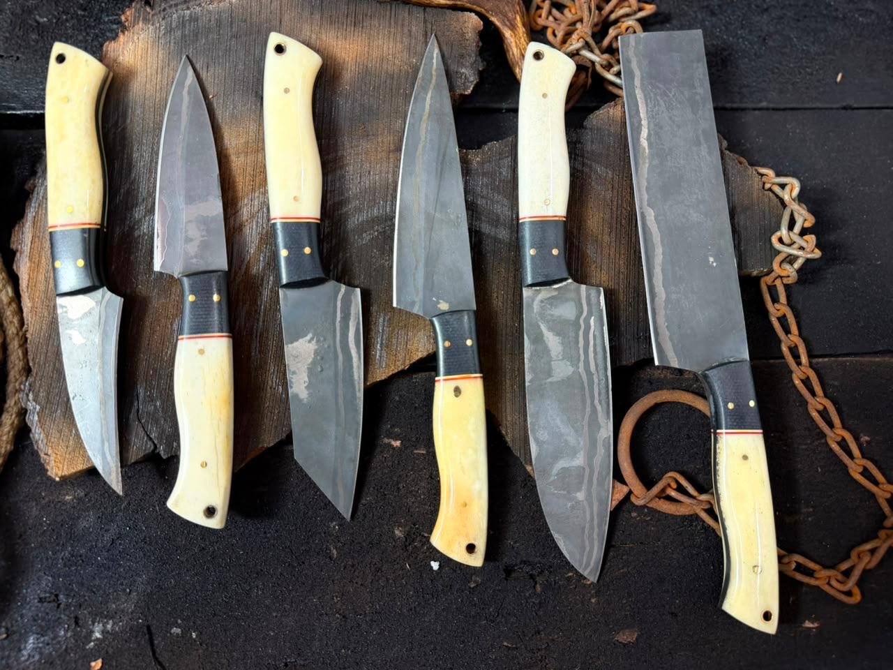 Set of knives with wooden handles on a dark surface