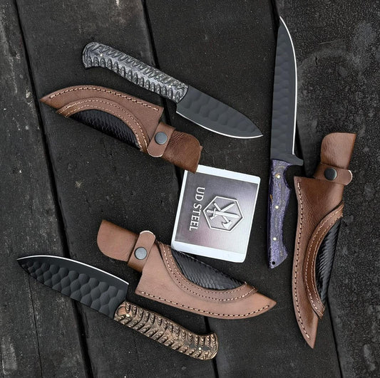 Knives with leather sheaths on a dark surface, featuring the UD Steel logo.