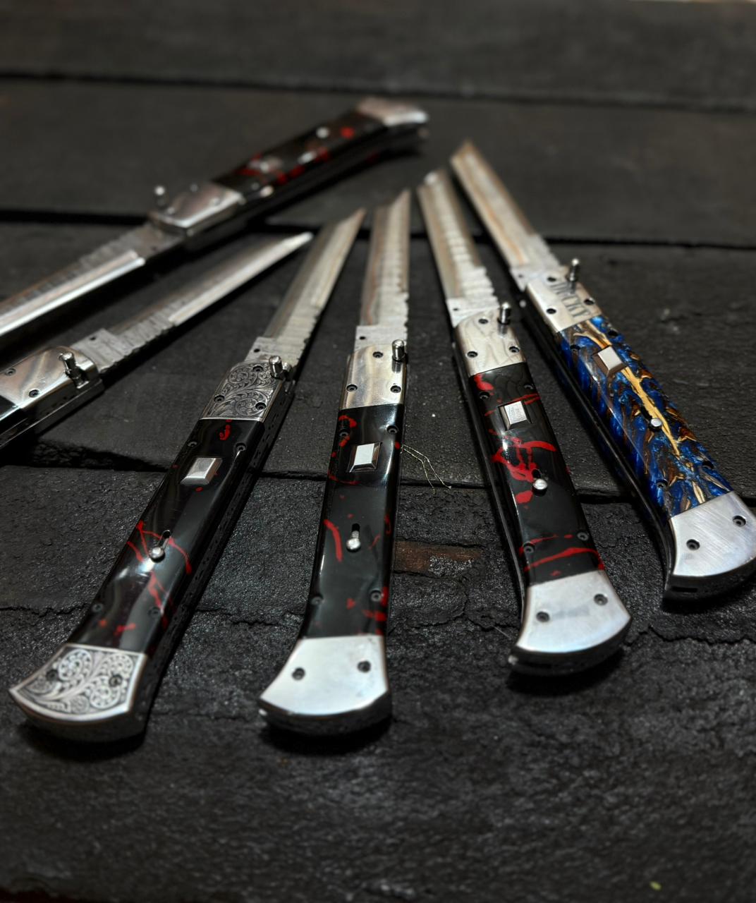 Set of decorative knives with artistic handles on a dark surface
