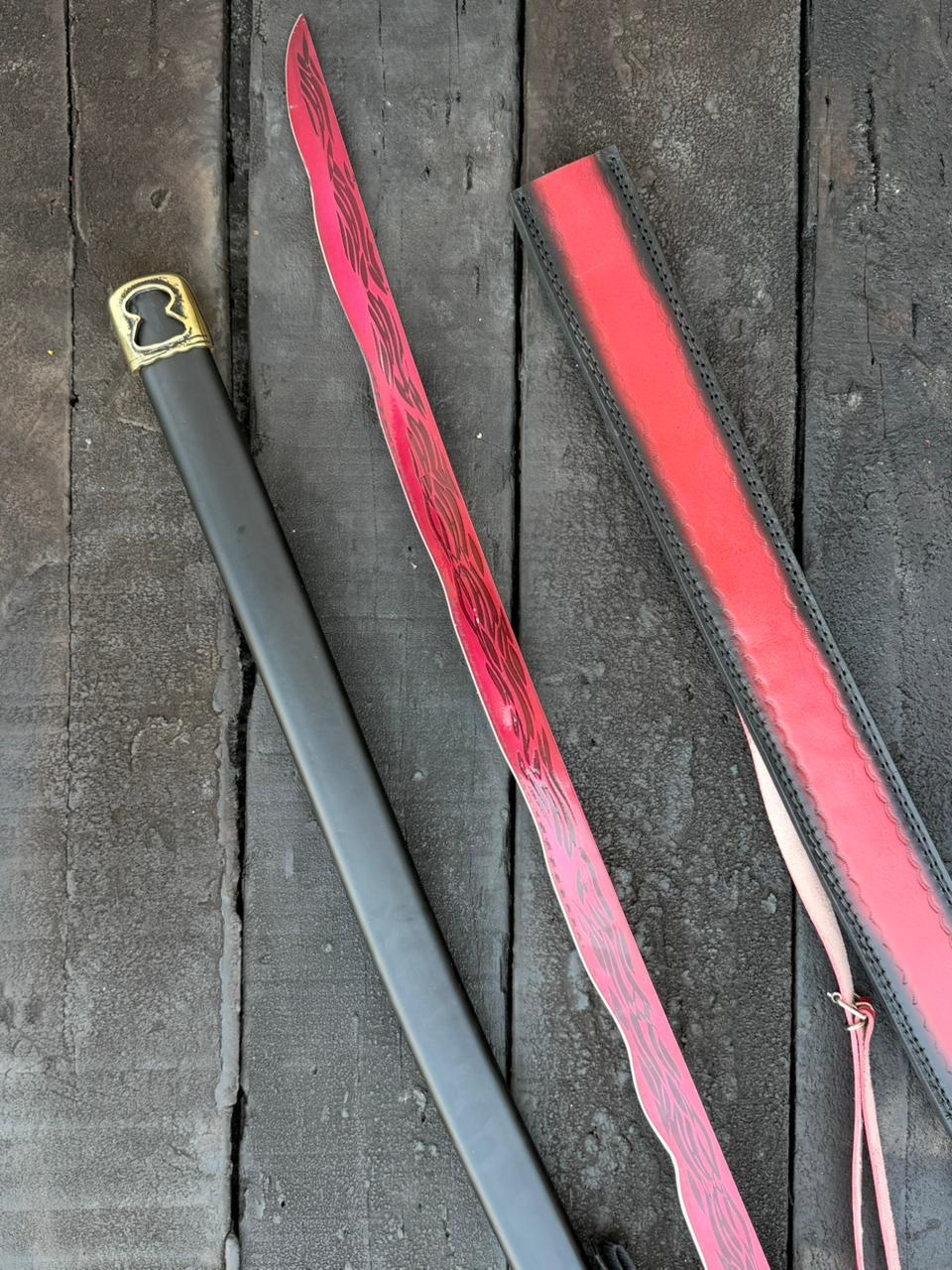 Gray riding crop with red leather handle on a dark wooden surface