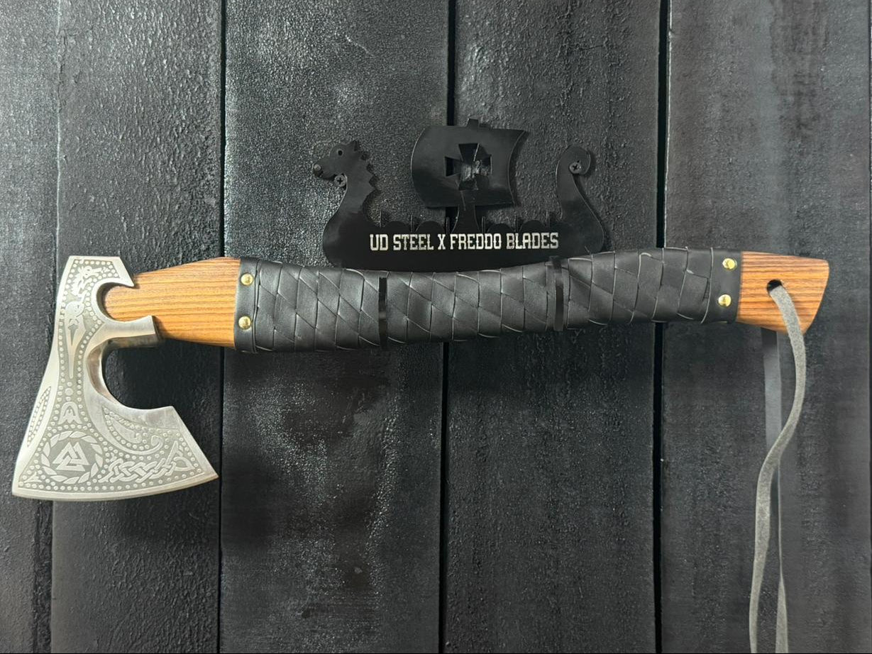 Decorative axe with wooden handle and metal blade on a dark wooden background
