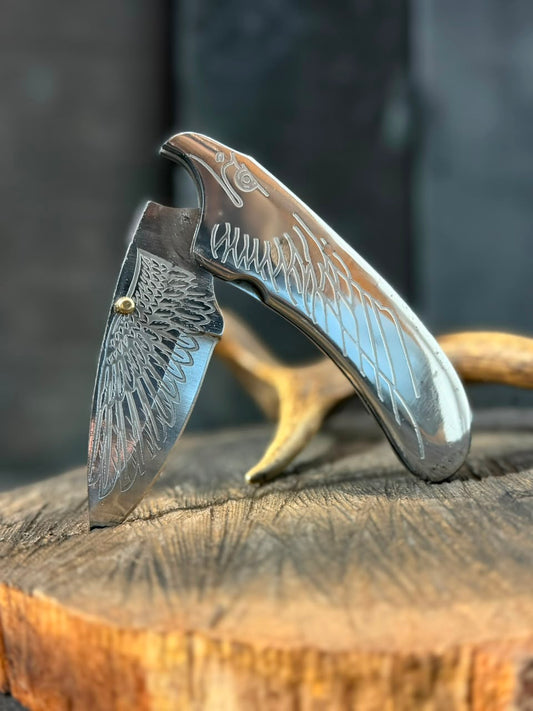 Decorative pocket knife with engraved design on a wooden surface