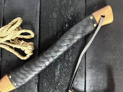 Black leather sheath with wooden handle on a dark surface
