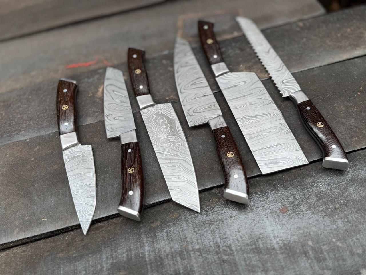 Set of six Damascus knives with wooden handles on a metal surface