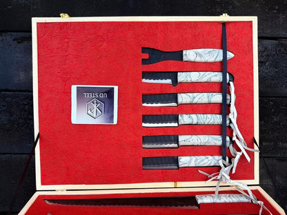 Set of knives in a red box with 'UD Steel' branding on a dark wooden background