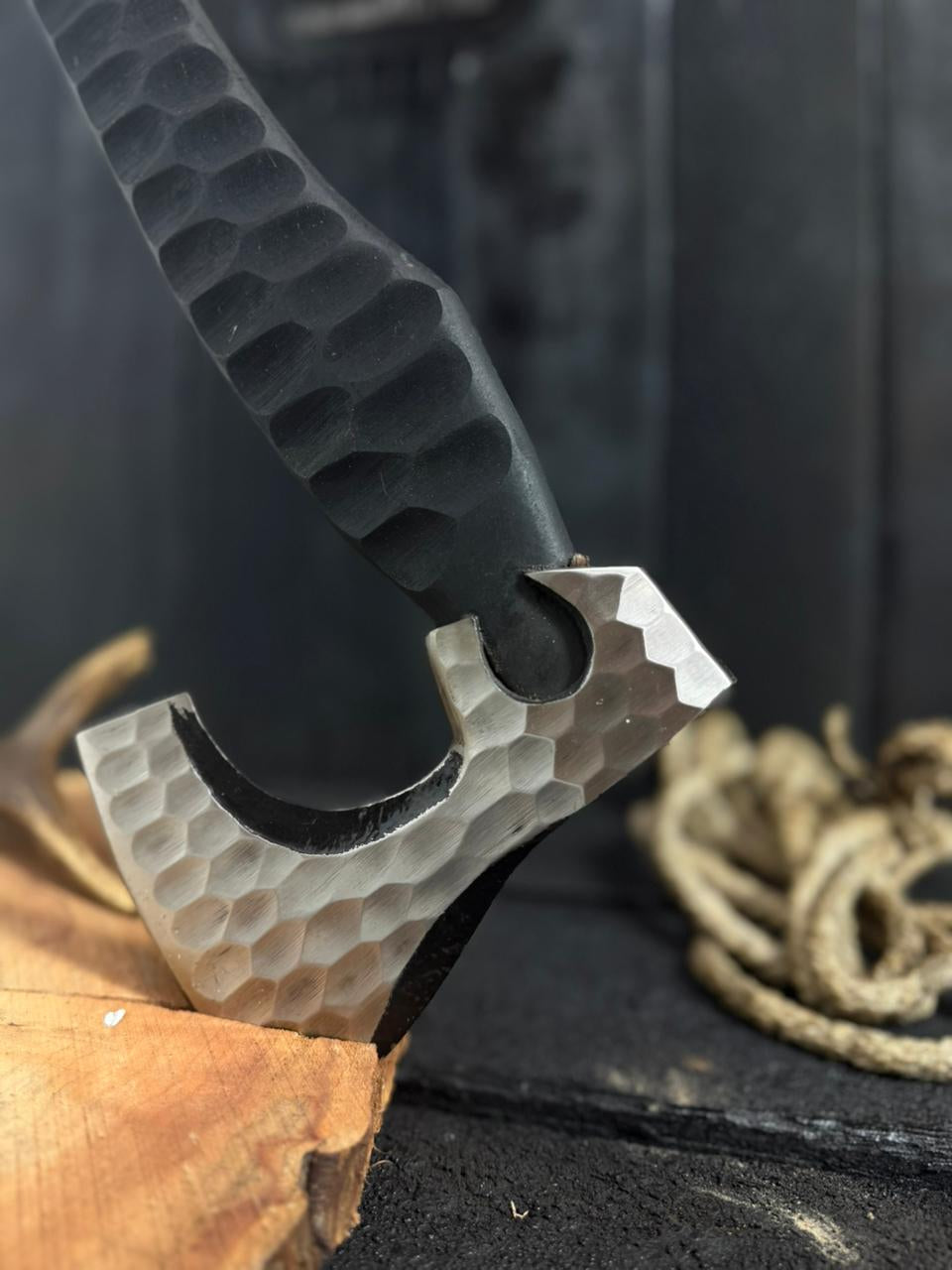 Close-up of a knife with a textured handle and metallic blade on a dark background.