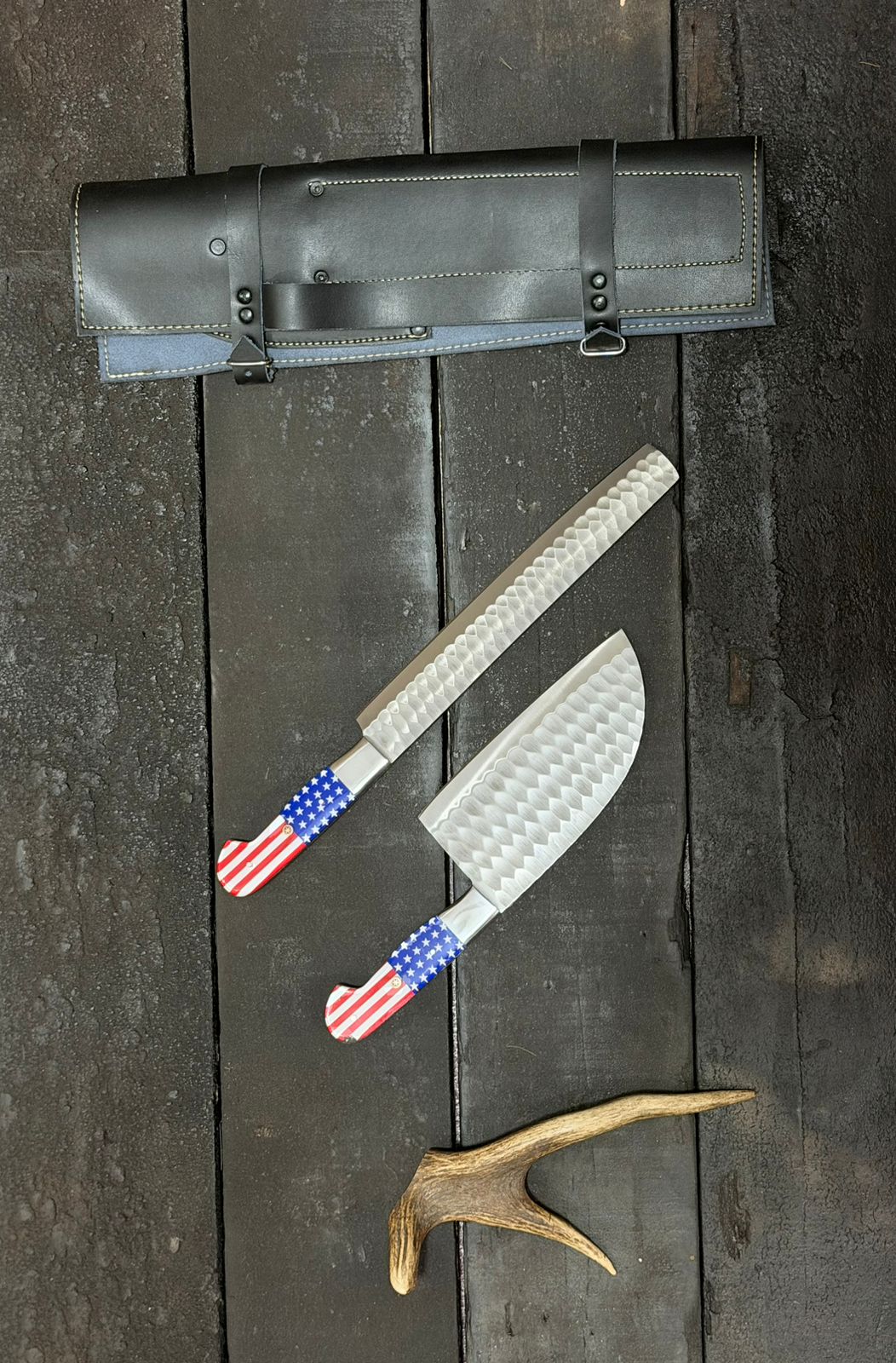 Two wooden-handled knives on a dark surface with blurred background