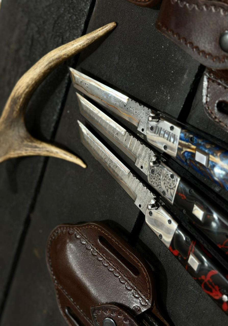 Forked antler and knife with leather sheath on a dark surface