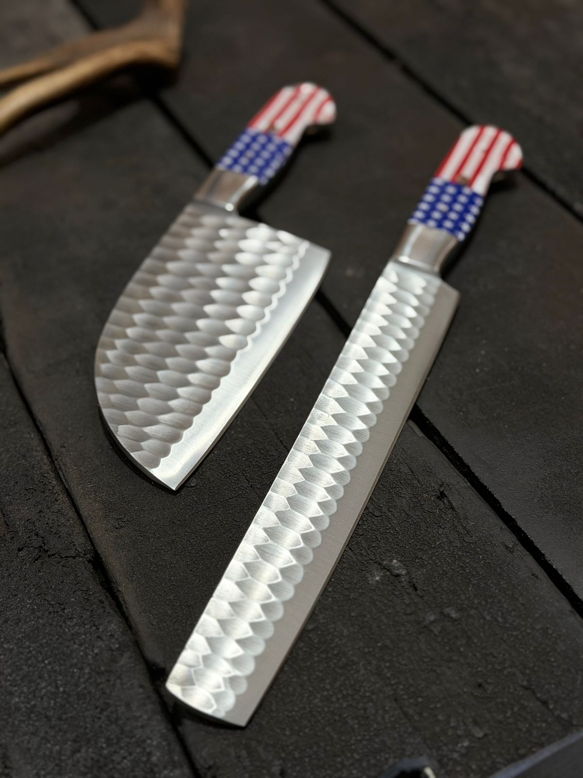 Two knives with decorative handles on a dark surface