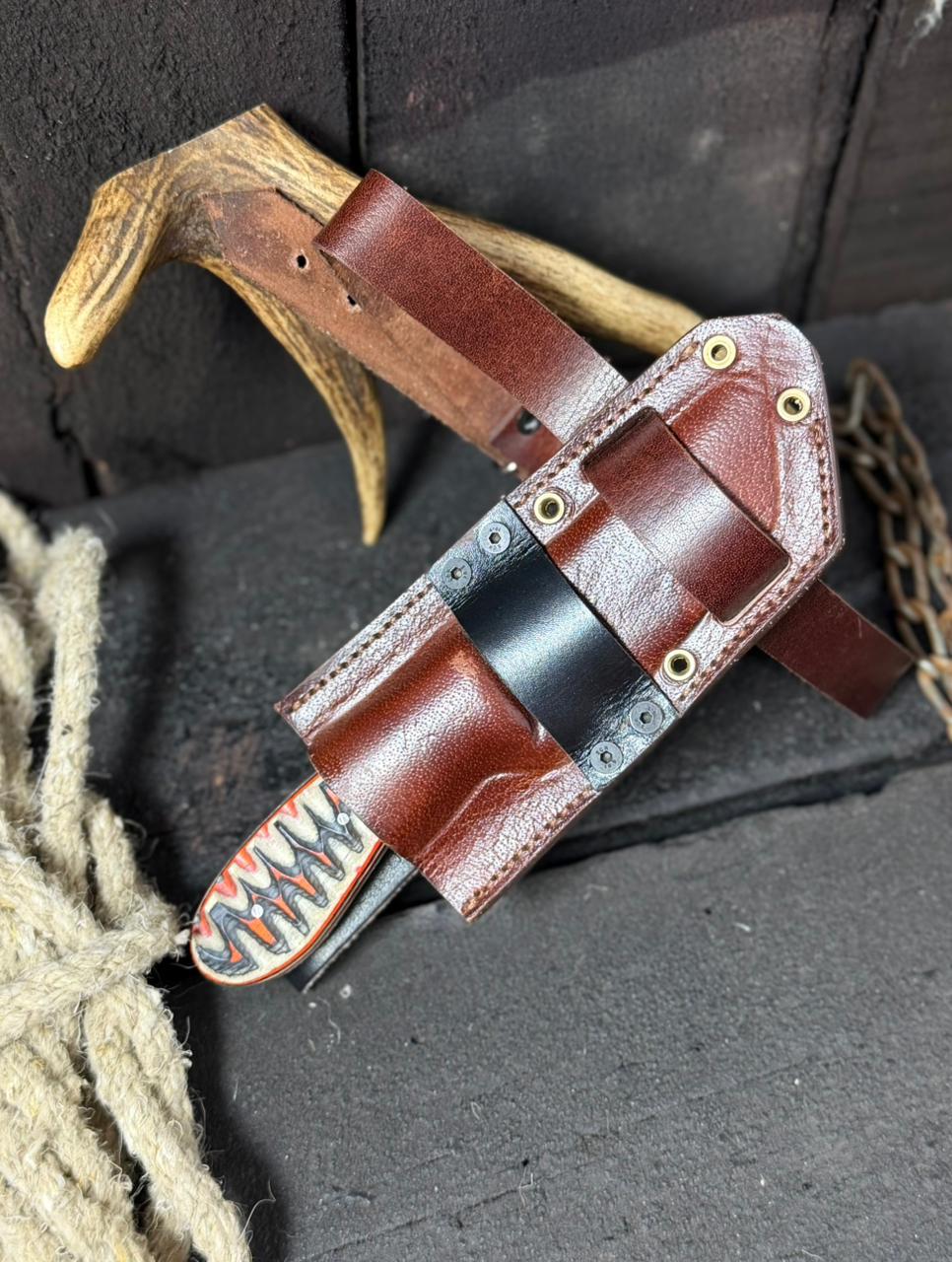 Brown leather knife sheath with decorative pattern on a dark background