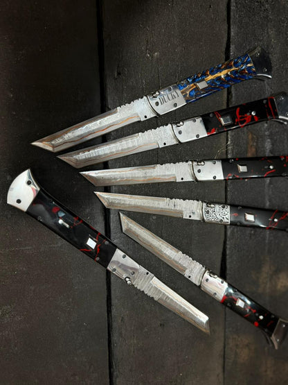 Set of folding knives with metallic blades and black handles on a dark surface