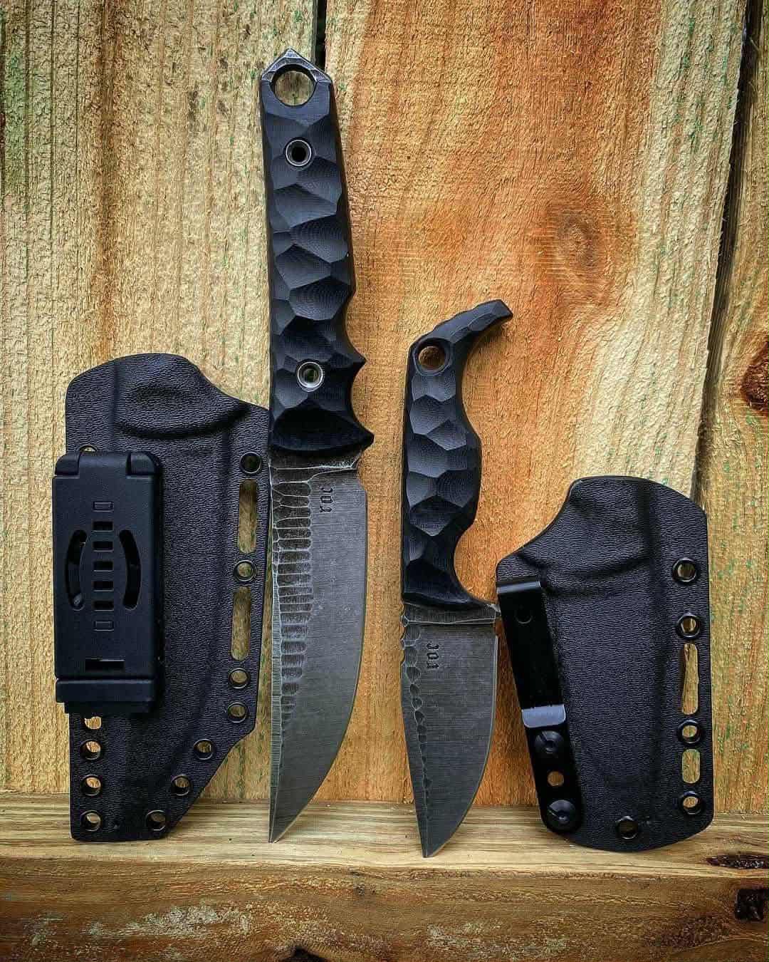 Two knives with sheaths on a wooden surface