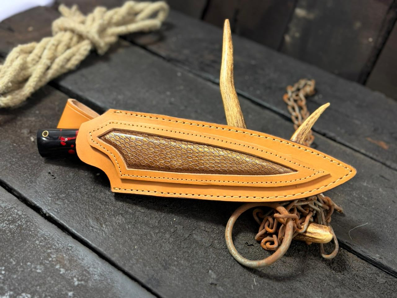 Leather archery nock cap on a wooden surface with twine