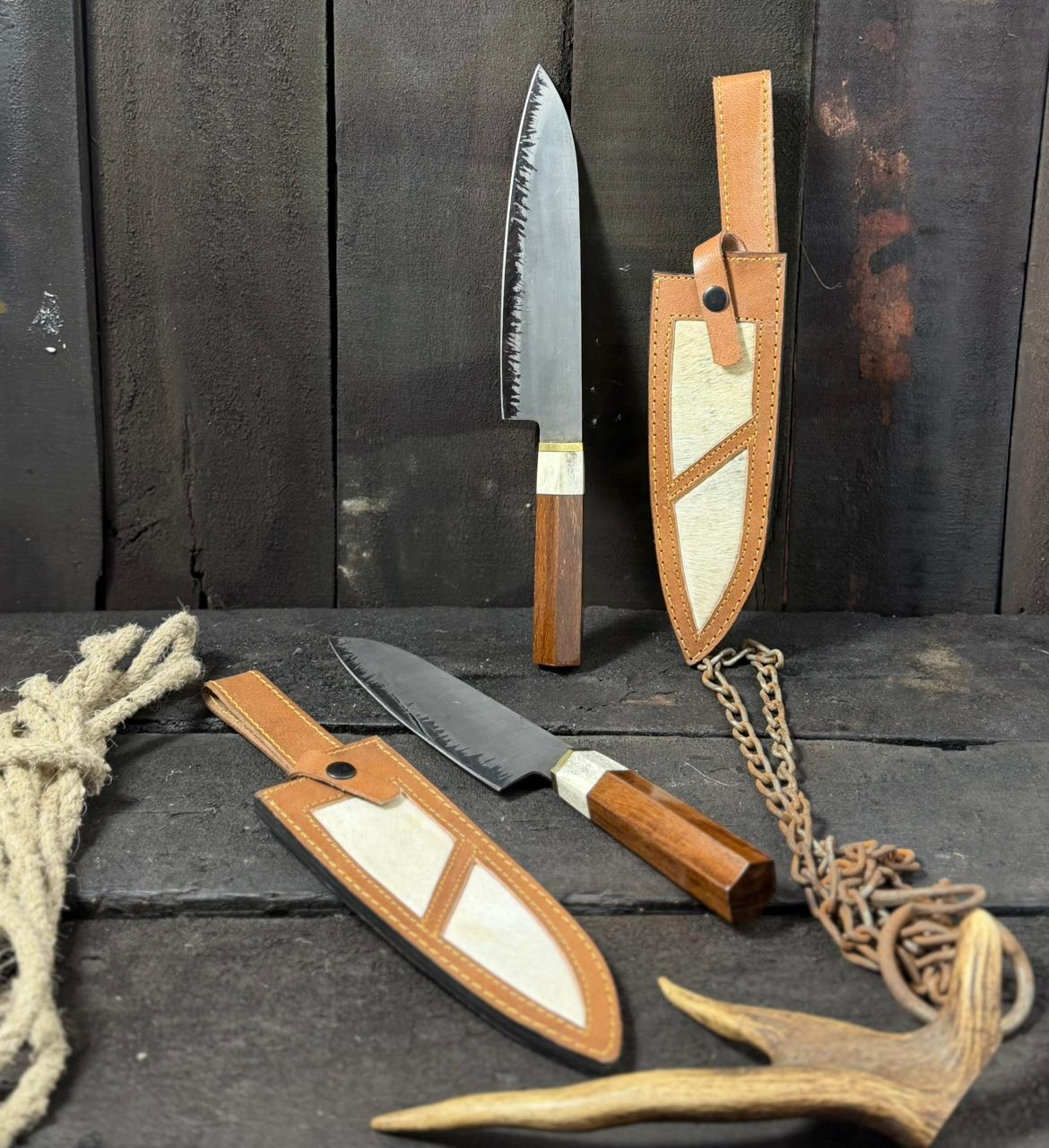 Two knives with leather sheaths on a dark wooden surface.