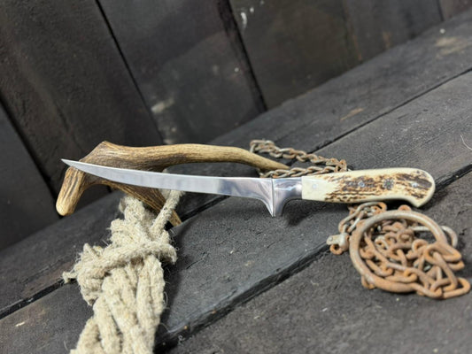 Knife with wooden handle and antler on a wooden surface
