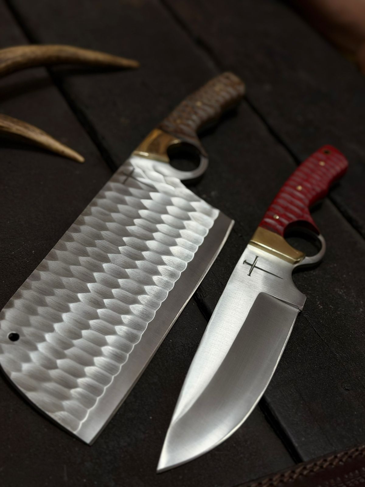 Two knives with different handles on a dark wooden surface