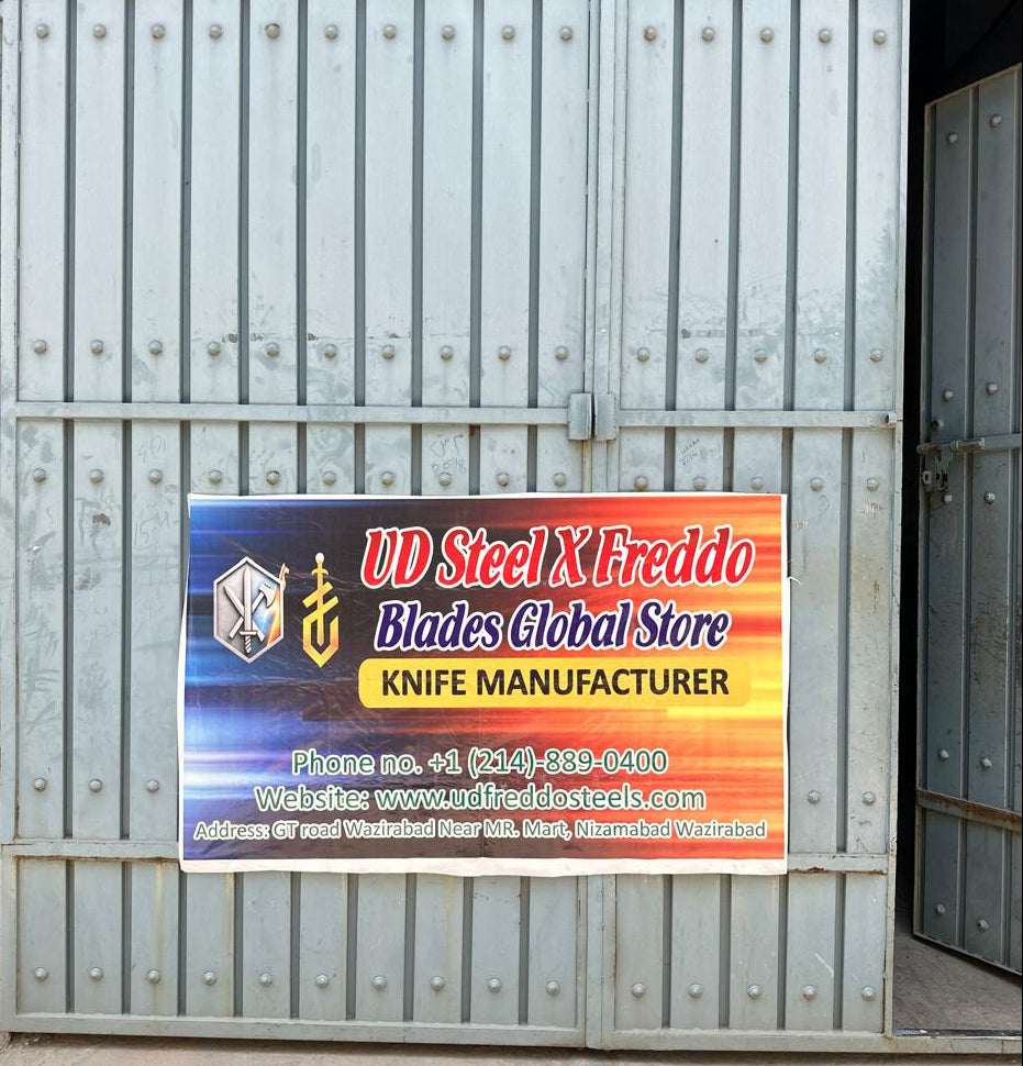 Metal gate with a colorful sign for UD Steel X Freddo Knife Manufacturer.